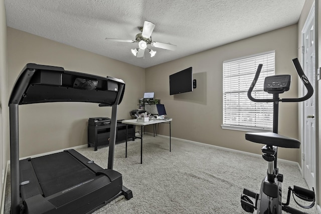 workout area featuring ceiling fan, light carpet, and a textured ceiling