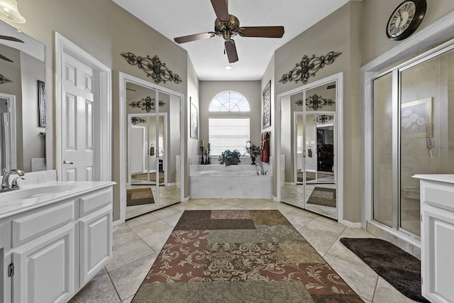 bathroom featuring a textured ceiling, vanity, independent shower and bath, ceiling fan, and tile patterned flooring