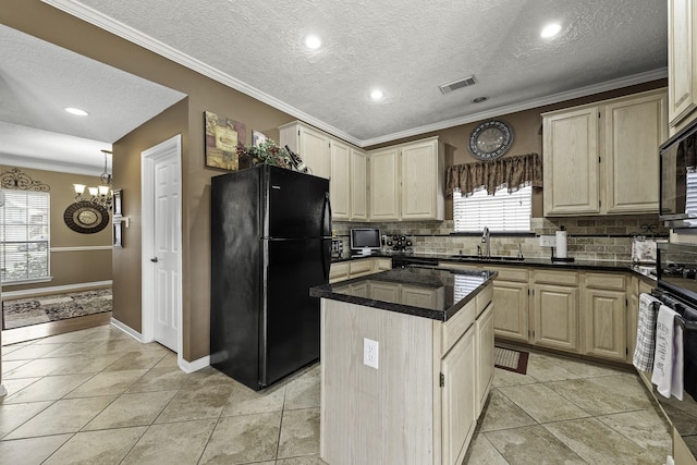 kitchen featuring black refrigerator, crown molding, sink, and a kitchen island