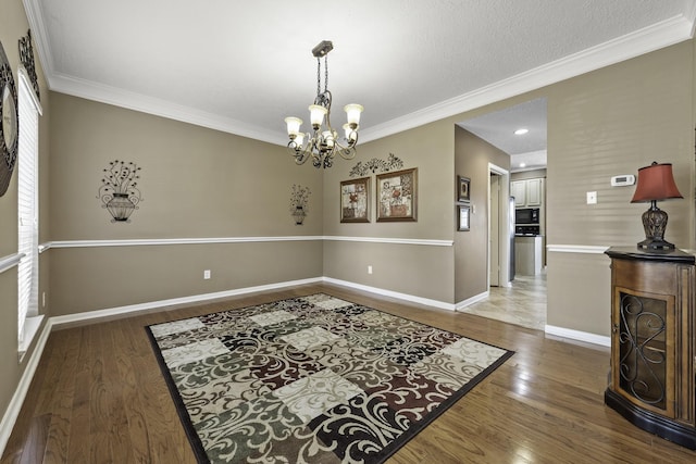 dining area featuring crown molding, dark hardwood / wood-style flooring, and a notable chandelier