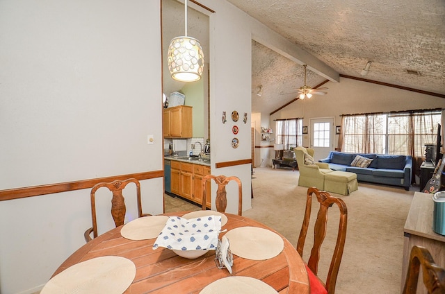 carpeted dining space featuring sink, vaulted ceiling with beams, and ceiling fan