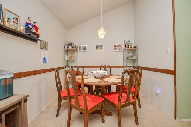 dining room featuring lofted ceiling and light carpet