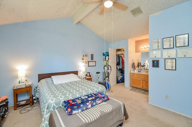 bedroom with ensuite bath, ceiling fan, lofted ceiling with beams, light carpet, and a closet