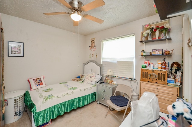 bedroom featuring ceiling fan, carpet floors, and a textured ceiling