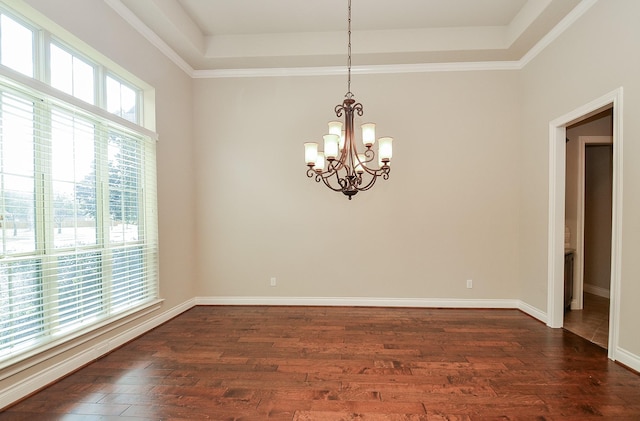 unfurnished room with a notable chandelier, dark hardwood / wood-style floors, and a raised ceiling