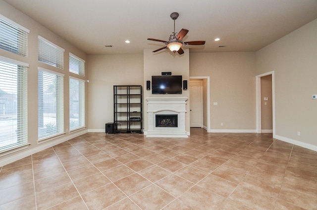 unfurnished living room featuring ceiling fan, a towering ceiling, and light tile patterned floors