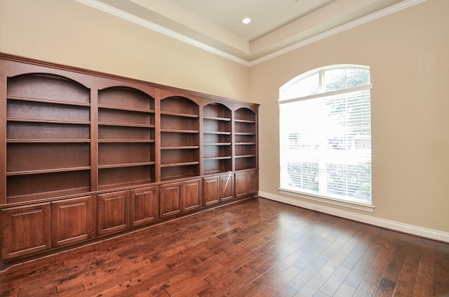 interior space with crown molding, dark hardwood / wood-style floors, and a raised ceiling