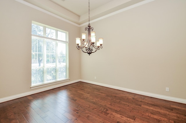 unfurnished room featuring dark wood-type flooring, ornamental molding, a raised ceiling, and a chandelier