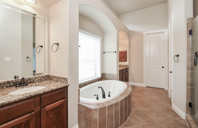 bathroom featuring vanity, plus walk in shower, and tile patterned flooring