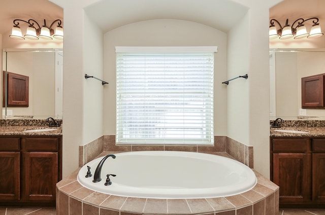 bathroom featuring vanity and tiled bath