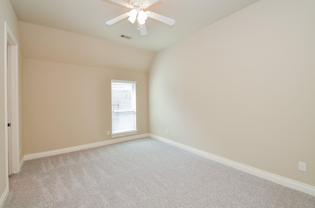 spare room featuring vaulted ceiling, light colored carpet, and ceiling fan