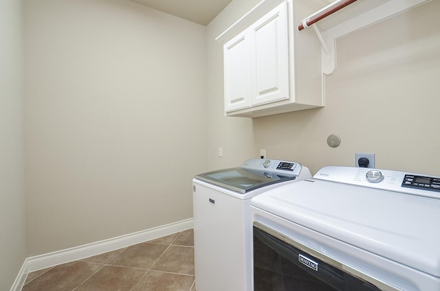 laundry room featuring cabinets, washer and dryer, and light tile patterned floors