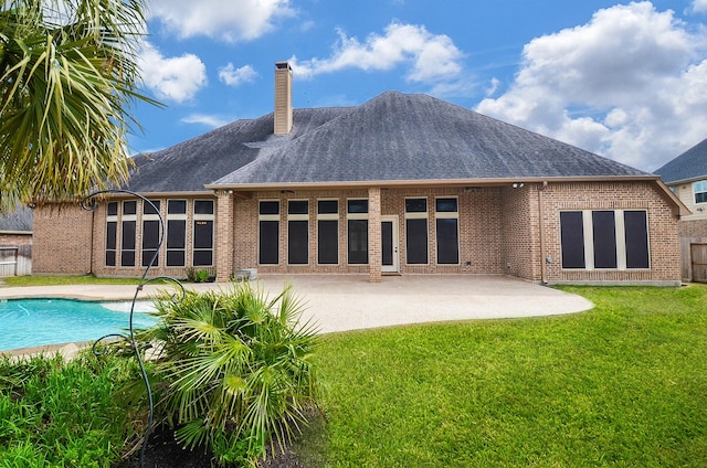 rear view of property featuring a lawn and a patio