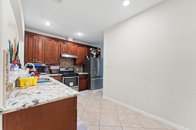 kitchen featuring sink, decorative backsplash, light tile patterned floors, light stone counters, and stainless steel appliances