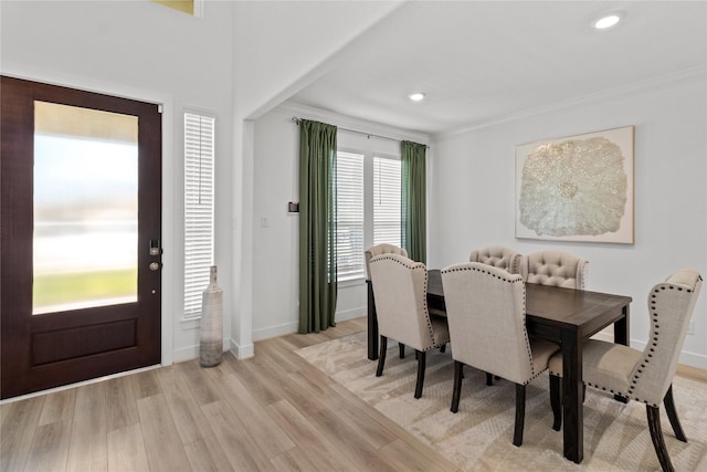 dining space with light wood-style floors, baseboards, crown molding, and recessed lighting