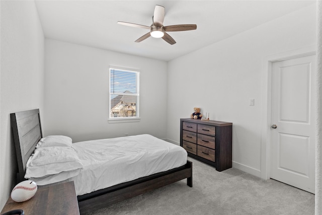 bedroom with a ceiling fan, light carpet, and baseboards