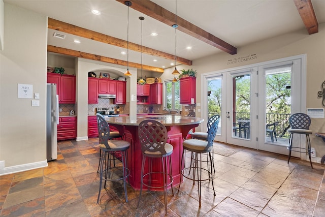 1017 Coventry Rd, Spicewood, TX 78669 - kitchen featuring stainless steel appliances, beam ceiling, decorative backsplash, recessed lighting, and reddish brown cabinets