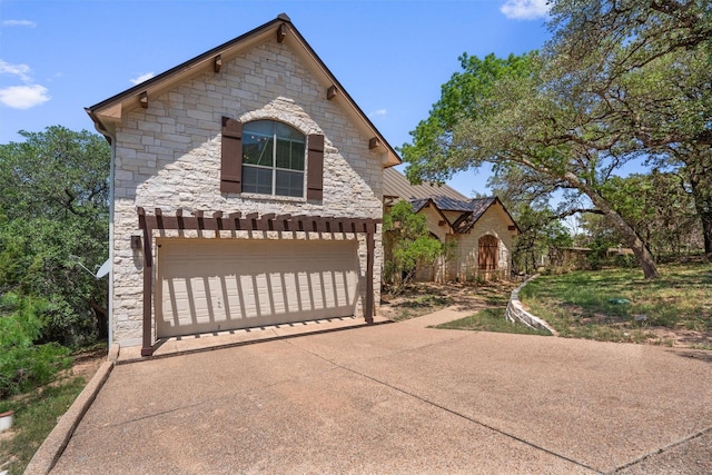 1017 Coventry Rd, Spicewood, TX 78669 - view of front facade featuring stone siding and a garage
