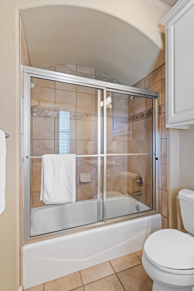 1017 Coventry Rd, Spicewood, TX 78669 - bathroom with toilet, bath / shower combo with glass door, tile patterned floors, and vaulted ceiling