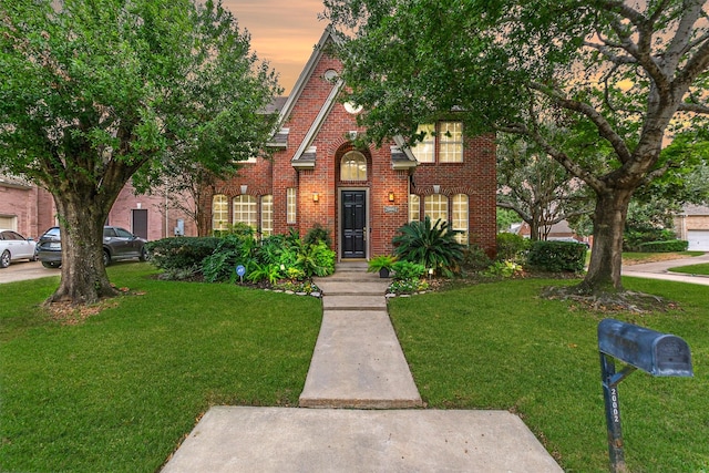 view of front facade featuring brick siding and a front lawn