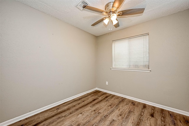 spare room with ceiling fan, wood-type flooring, and a textured ceiling