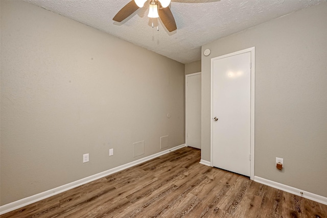 spare room with ceiling fan, light hardwood / wood-style flooring, and a textured ceiling