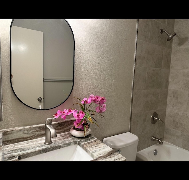 full bathroom with vanity, tiled shower / bath combo, and toilet