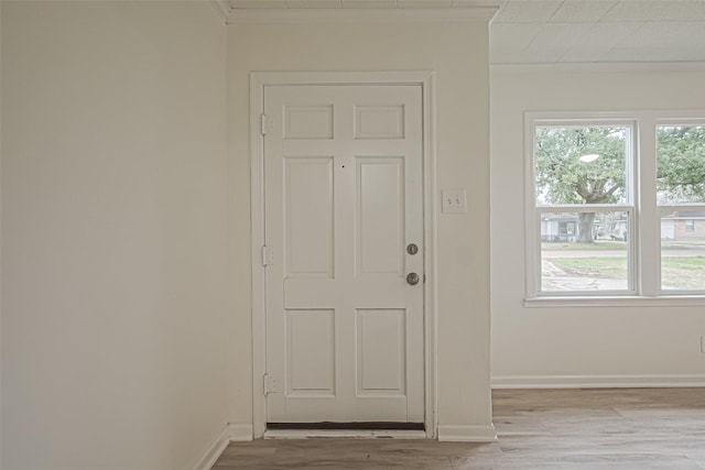 entryway featuring light wood-type flooring and ornamental molding