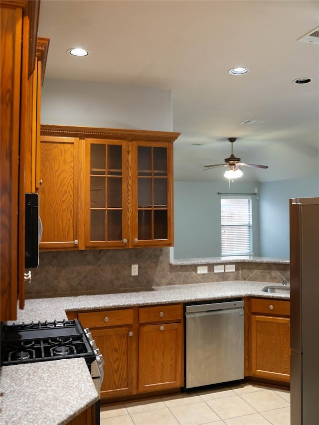 kitchen featuring sink, light tile patterned floors, ceiling fan, appliances with stainless steel finishes, and tasteful backsplash