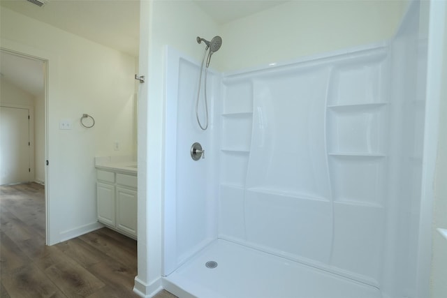 bathroom featuring vanity, walk in shower, and wood-type flooring