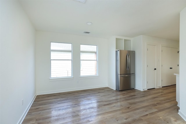 kitchen with light wood-type flooring and stainless steel refrigerator