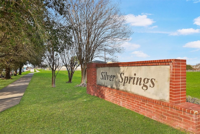 community / neighborhood sign with a yard