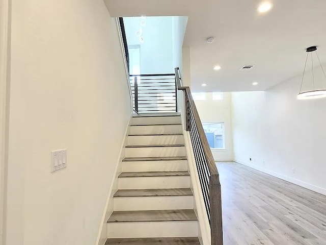 stairs featuring hardwood / wood-style floors