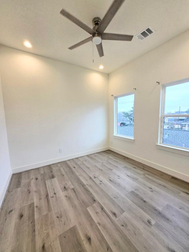 empty room with ceiling fan and light hardwood / wood-style floors