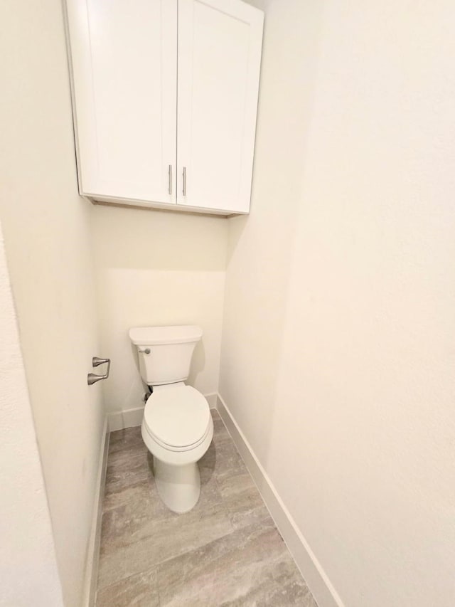 bathroom with hardwood / wood-style flooring and toilet