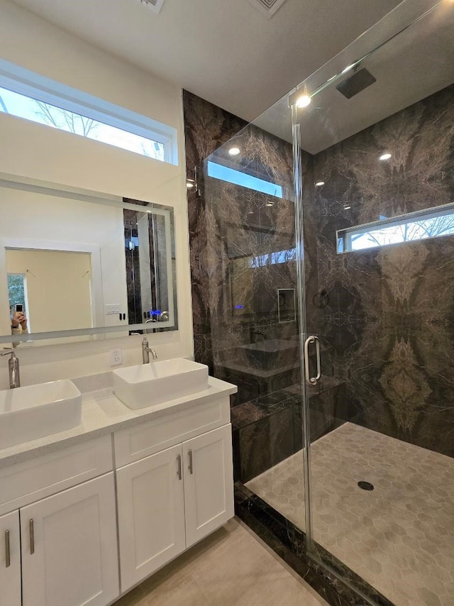 bathroom with an enclosed shower, vanity, and plenty of natural light