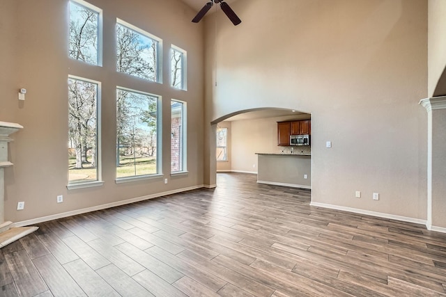 unfurnished living room with ceiling fan and light wood-type flooring