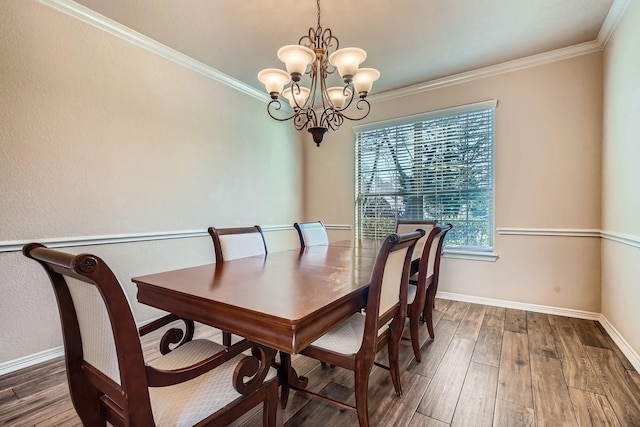 dining space with ornamental molding, hardwood / wood-style floors, and an inviting chandelier