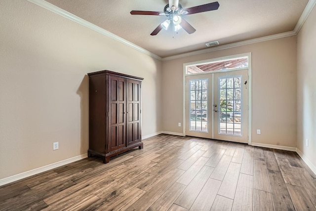 spare room featuring ornamental molding, light hardwood / wood-style floors, french doors, and ceiling fan