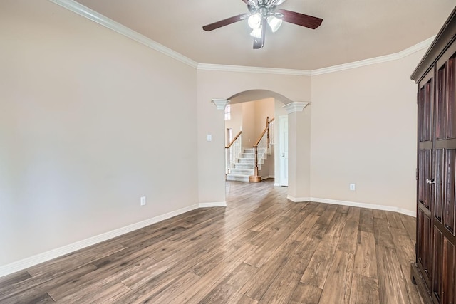 empty room featuring crown molding, ceiling fan, wood-type flooring, and ornate columns