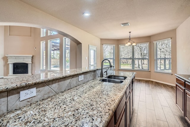 kitchen featuring pendant lighting, sink, and light stone counters