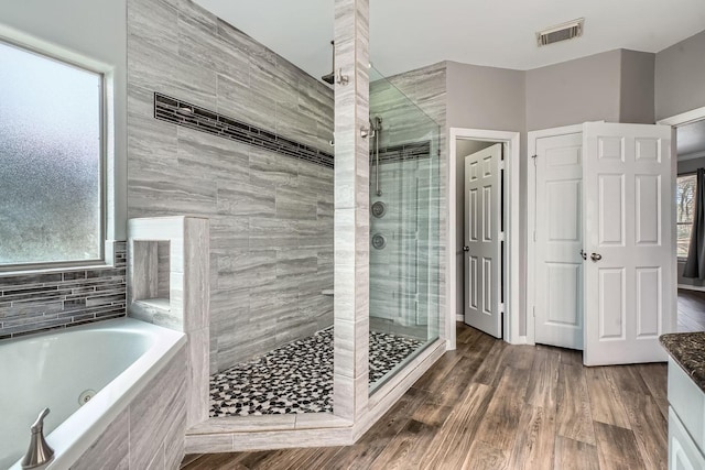 bathroom with hardwood / wood-style flooring and plus walk in shower