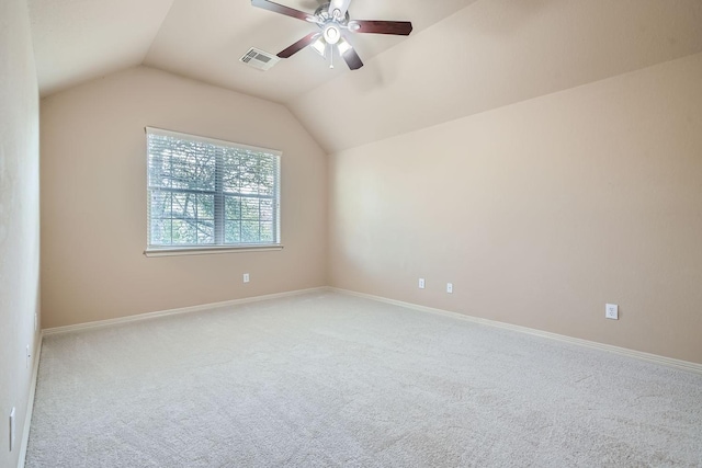 carpeted spare room featuring vaulted ceiling and ceiling fan