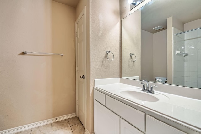 bathroom with tiled shower, vanity, and tile patterned flooring