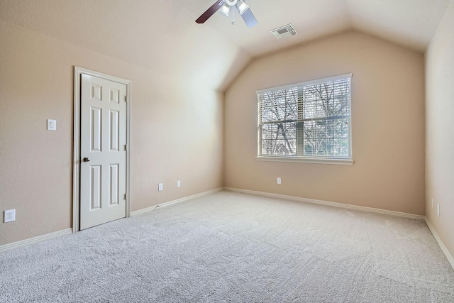 carpeted spare room featuring lofted ceiling and ceiling fan