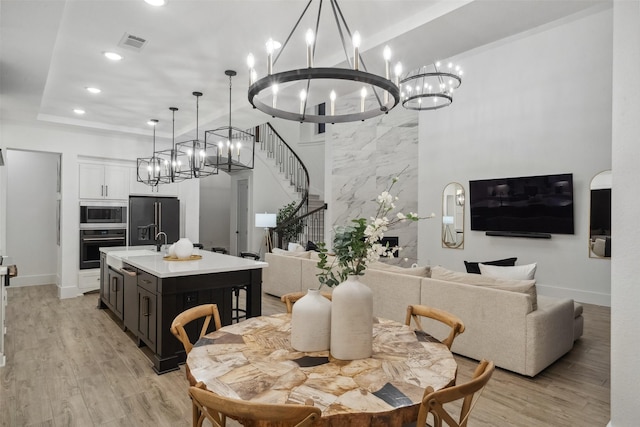 dining area with light wood-style floors, recessed lighting, visible vents, and stairway