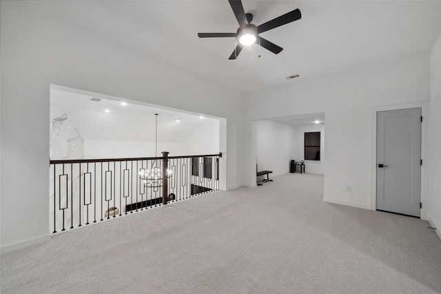 carpeted spare room with visible vents, baseboards, and ceiling fan with notable chandelier