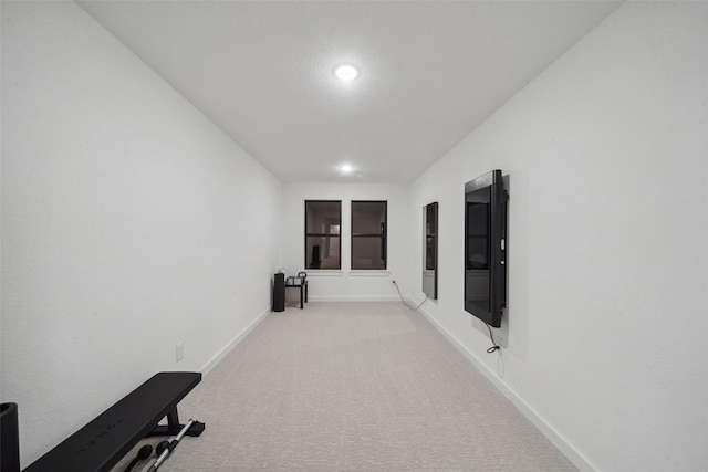 hallway with carpet floors and baseboards