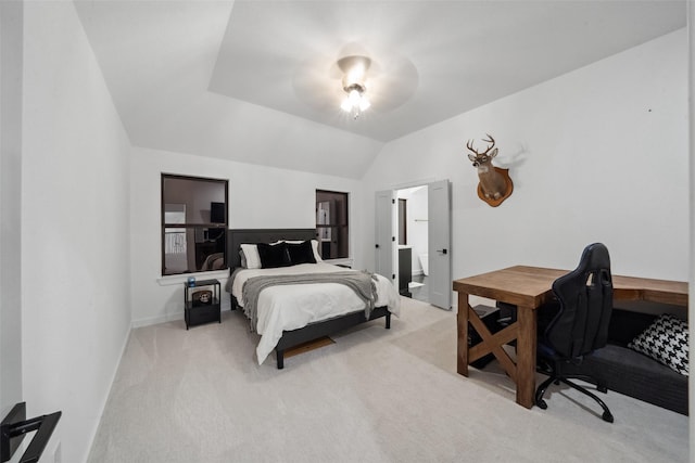 bedroom featuring lofted ceiling, light colored carpet, a ceiling fan, ensuite bath, and baseboards