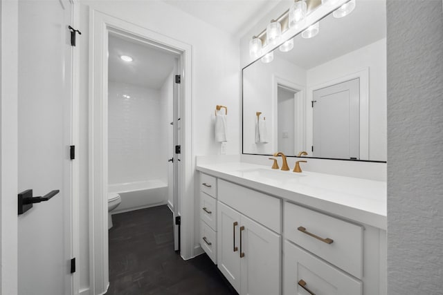 bathroom featuring toilet, bathing tub / shower combination, wood finished floors, and vanity